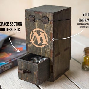 May include: A wooden storage box with a drawer, featuring a logo and a hinged lid. The box is stained dark brown with lighter brown accents. The text "THE STORAGE SECTION FOR COUNTERS, ETC." is visible. The box is designed for storing game accessories.