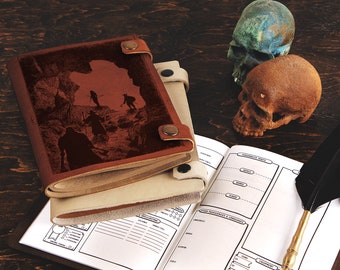 May include: A brown leather-bound journal with a silhouette image of adventurers exploring a cave. The journal is open to a blank page with a quill pen and two decorative skulls on a wooden surface.