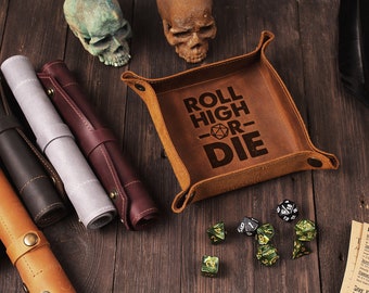 May include: A brown leather dice tray with the text "Roll High or Die" and a dice symbol. The tray is on a wooden surface with dice and other gaming accessories.