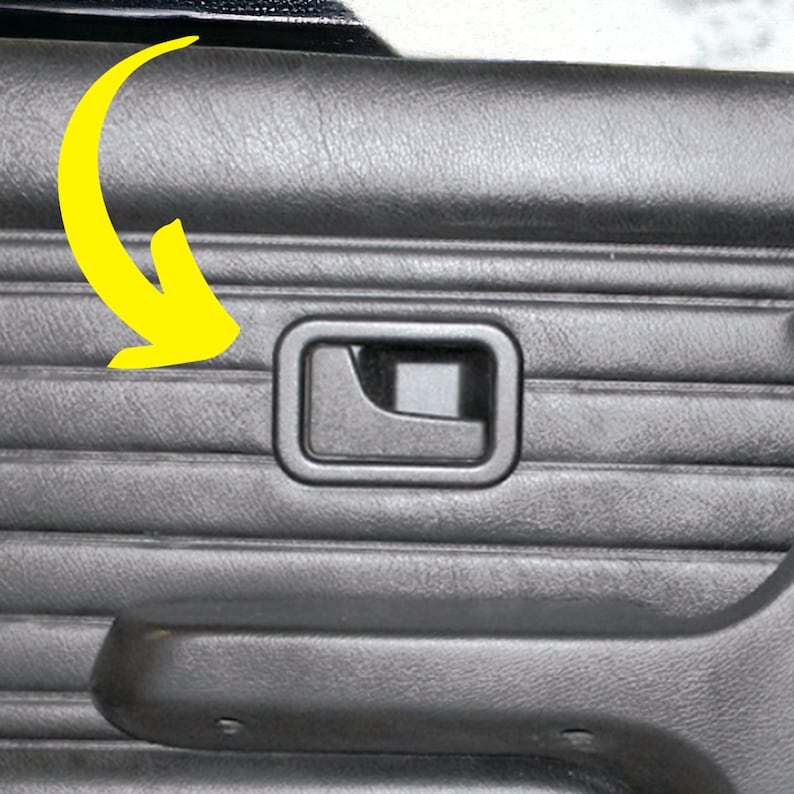 Puede incluir: Primer plano del interior de una puerta de coche negra con un panel texturizado y una manija de puerta de pl&aacute;stico negro. La manija tiene una forma rectangular con un peque&ntilde;o recorte rectangular en el centro.