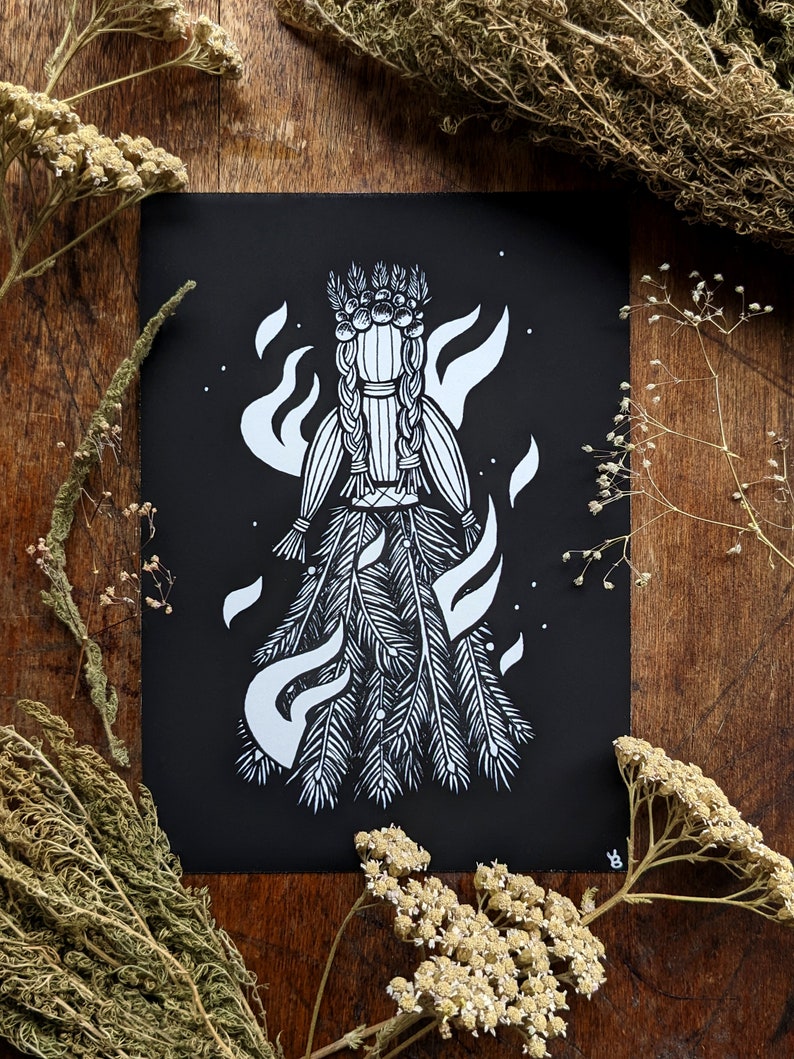 Puede incluir: Impresi&oacute;n art&iacute;stica en blanco y negro que representa una figura estilizada con una corona y una falda fluida, rodeada de llamas. La obra de arte est&aacute; sobre un fondo negro, con plantas y hierbas secas que enmarcan la imagen.