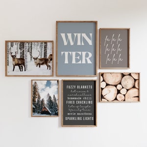 May include: A collection of six framed prints with winter themes. The prints feature a snowy forest scene with reindeer, a woodsy cabin, a stack of logs, and text that reads "WIN TER", "la la la", and "FUZZY BLANKETS hot cocoa & marshmallows homemade chili FIRES CRACKLING lots of laughs family time movie marathons SPARKLING LIGHTS".