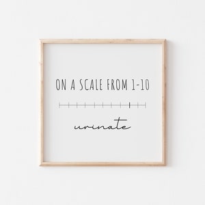 Puede incluir: Un cartel enmarcado con el texto "ON A SCALE FROM 1-10" sobre una línea horizontal con diez marcas de graduación espaciadas. Debajo de la línea, la palabra "urinate" está escrita en cursiva. El marco es marrón claro.