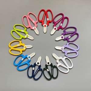 May include: A set of ten colorful floral shears with a variety of handle colors, including yellow, blue, green, pink, and purple. The shears are arranged in a circle on a gray background.