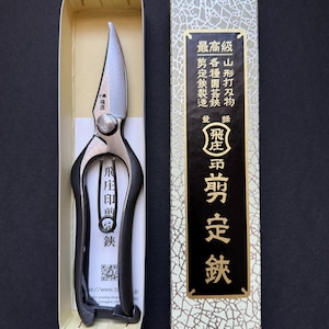 May include: A black and silver pruning shears with a black handle and a silver blade. The shears are in a white box with Japanese text on the box. The text on the box reads "Highest Quality", "Yamagata Cutting Tools", "Various Garden Shears", "Pruning Shears Manufacturing", "Pruning Shears".
