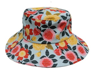 May include: A light blue bucket hat with a vibrant floral pattern. The hat features large red, yellow, and pink flowers with green leaves. The brim is wide, offering sun protection. This hat is a stylish accessory for outdoor activities.