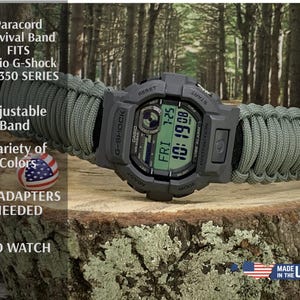 May include: A gray Casio G-Shock watch with a green digital display, featuring a paracord survival band in olive green. The watch band is adjustable and fits the GD-350 series. The image includes text that says "Made in the USA".