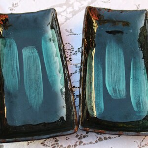 May include: Two rectangular ceramic serving dishes with a dark green glaze and a light green brushstroke design.