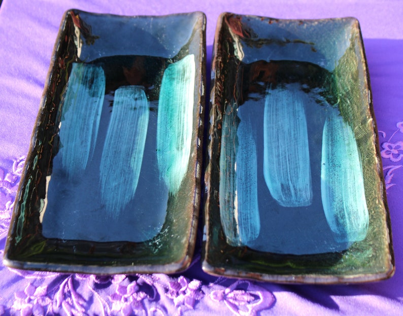 May include: Two rectangular ceramic serving dishes with a dark blue glaze and light blue brushstrokes.