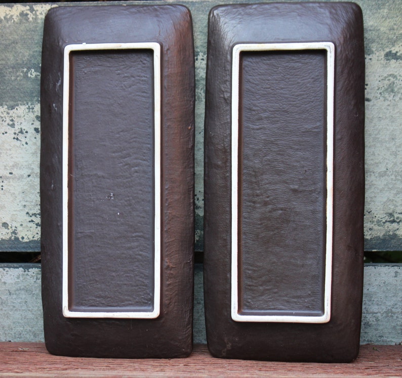 May include: Two rectangular brown ceramic serving trays with white trim. The trays have a textured surface.