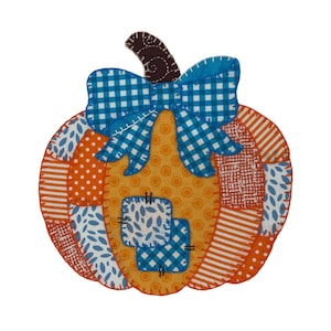 May include: A patchwork pumpkin decoration with a blue gingham bow and a brown stem. The pumpkin is made of orange, white, and blue fabric pieces with various patterns, including polka dots and stripes. The center has two square patches.