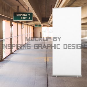May include: A white retractable banner stand in a car park. The banner is blank and ready for your design. The sign above reads "Parking Exit".