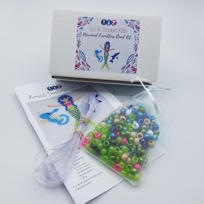 Peut inclure: Un kit de perles de sir&egrave;ne avec une bo&icirc;te blanche, un sac transparent de perles et des instructions. Le kit comprend des perles bleues, blanches, noires, couleur chair, vert clair, vert fonc&eacute; et roses. Il comprend &eacute;galement 6,5 m&egrave;tres de cordon de la&ccedil;age en plastique et 3 crochets de cordon.