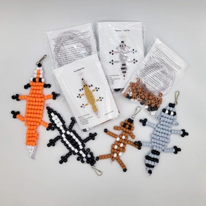 May include: Five beaded animal keychains, including a fox, a lizard, a raccoon, a skunk, and a turtle. Each keychain is made with colorful beads and comes with instructions and string for making your own.