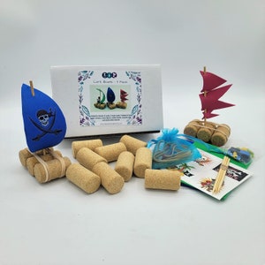 May include: A set of cork boats for kids to make. The set includes 4 cork boats, 1 wood mast, 1 sail, 1 rubber band, 1 wooden dowel, 1 wooden flag, 1 pirate flag, 1 pirate skull and crossbones, 1 instruction sheet, and 1 bag of colorful beads. The set is packaged in a box with the words "Cork Boats - 4 Pack" printed on it.