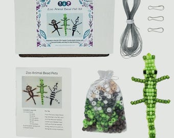 May include: A Zoo Animal Bead Pet Kit including a white box with product text, a coil of gray plastic lacing cord, three metal lanyard hooks, an instruction sheet, a clear bag of assorted beads, and a finished green beaded lizard figure.