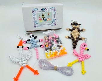 May include: A craft kit featuring a white box labeled Otter Bead Pet Kit, a bag of assorted plastic pony beads, a coil of clear lacing cord, and four assembled bead animal figures including a white bird, a gray lizard, a brown otter, and a pink flamingo.