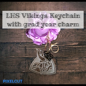 May include: A purple flower keychain with a gold chain and a clear acrylic charm with the text "LHS" and a Viking helmet design. The charm also has the number "23" on it.