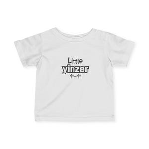 May include: White t-shirt with the text "Little Yinzer" in black, along with a bridge graphic. The shirt is short-sleeved and appears to be made of cotton or a similar fabric. The design is centered on the front of the shirt.