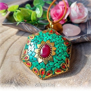 May include: A hexagonal pendant necklace with a green and gold mosaic design. The pendant features a red gemstone in the center and is accented with gold accents.