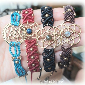 May include: Four macrame bracelets with gold flower of life charms. The bracelets are in turquoise, red, black, and brown.