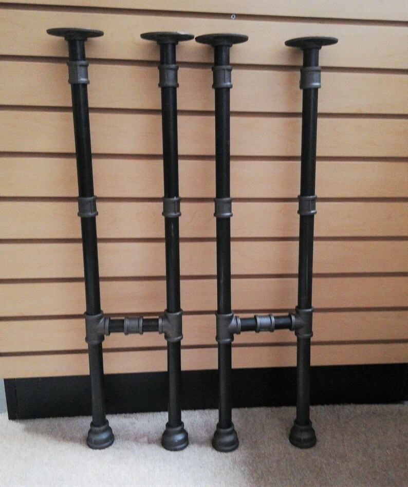 May include: Three black metal pipe table legs with a crossbar. The legs are about 24 inches tall.