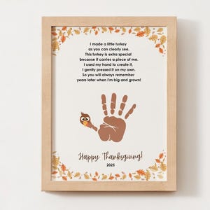 May include: Framed Thanksgiving artwork featuring a handprint turkey design. The artwork includes a poem and the text "Happy Thanksgiving! 2025". The frame is made of light-colored wood, and the background is off-white.