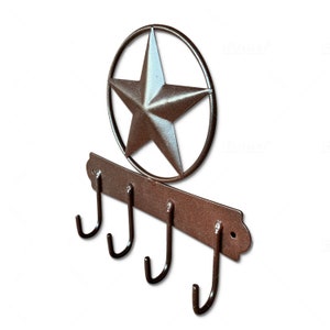 May include: Rustic metal key holder with four hooks and a star-shaped design. The key holder is painted in a brown color.