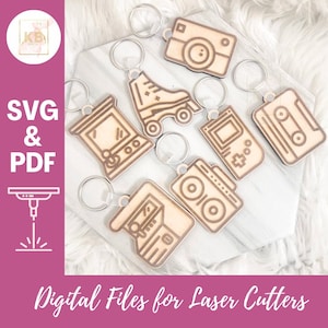 May include: Set of eight laser cut wooden keychain designs featuring retro themes like a cassette tape, a video game console, a boombox, roller skates, a camera, and a pinball machine. SVG and PDF digital files for laser cutters.