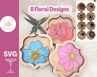 May include: Eight floral designs for laser cutting. The designs are in a variety of colors, including pink, blue, and red. The designs are in a square shape with rounded corners. The designs are on a wooden background. The text "8 Floral Designs" is at the top of the image. The text "SVG" is at the bottom left of the image. The text "Digital Files for Laser Cutters" is at the bottom of the image.