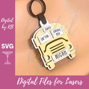 Könnte beinhalten: Ein gelber Schlüsselanhänger in Form eines Schulbusses mit weißen Akzenten und einem schwarzen Ring. Der Schlüsselanhänger trägt den Namen "Micah" und den Text "Tap for Contact Info". Der Text "Digital Files for Lasers" ist ebenfalls sichtbar.