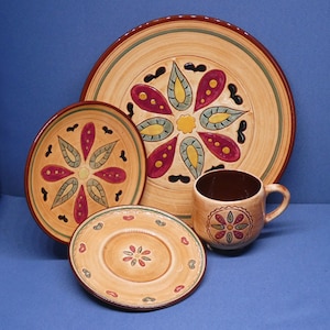 May include: A set of three ceramic dishes with a floral design. The dishes are in shades of brown, yellow, red, and green. The largest dish has a large floral design in the center, while the smaller dishes have smaller floral designs. The dishes are perfect for serving snacks or desserts.