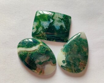 May include: Three green, white and brown agate cabochons. The cabochons are polished and have a smooth, glossy finish. The cabochons are oval, square and teardrop shaped.