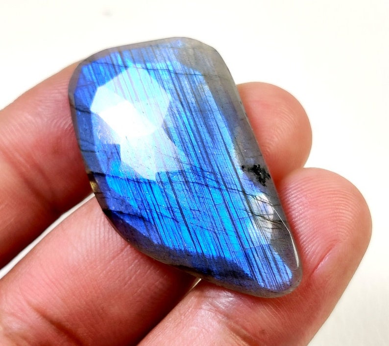 May include: A blue and gray labradorite gemstone with iridescent flashes of color.