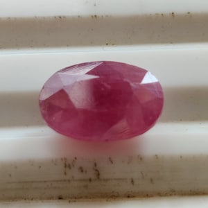 Op de afbeelding: Een roze ovale edelsteen met een facetgeslepen vorm.