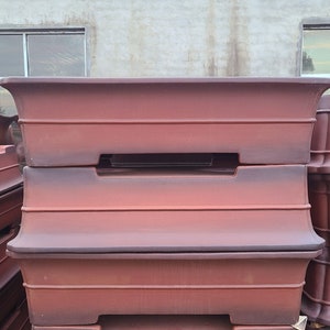 May include: Stacked terracotta plant pots in various sizes, with a reddish-brown glaze. The pots are unglazed on the inside and have a slightly textured surface.