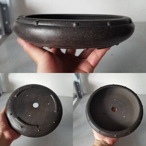 K&ouml;nnte beinhalten: Ein dunkelbrauner Keramik-Bonsai-Topf mit runder Form und texturierter Oberfl&auml;che. Der Topf hat einen erh&ouml;hten Rand mit kleinen, gleichm&auml;&szlig;ig verteilten Vertiefungen am Rand. Der Boden des Topfes hat ein Abzugsloch.