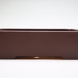 Könnte beinhalten: Ein rechteckiger brauner Keramik-Bonsai-Topf mit leicht abgerundetem Boden und Abzugslöchern.