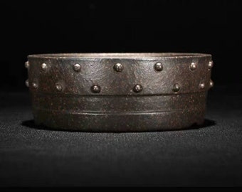 May include: A dark brown ceramic bonsai pot with a decorative band of metal studs around the rim.