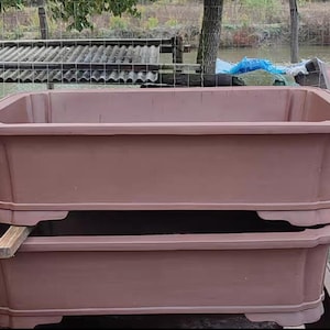 May include: Two brown terracotta rectangular planters stacked on top of each other. The planters have a slightly flared lip and a decorative lip around the top edge.