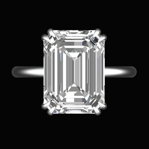 Könnte beinhalten: Ein silberner Ring mit einem großen, klaren Smaragdschliff-Diamanten.