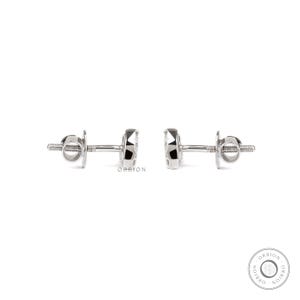 May include: A pair of silver stud earrings with a small round diamond in the centre of each earring.