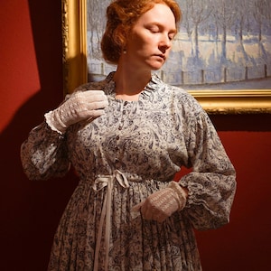 Vintage Midi dress with long voluminous sleeves and a placket. The dress features a drawstring at the waist and button closure. Lace embellishments adorn the sleeves and back of the dress. The color of the lace may vary while maintaining the color palette and artistic integrity. 
Fabric - viscose.