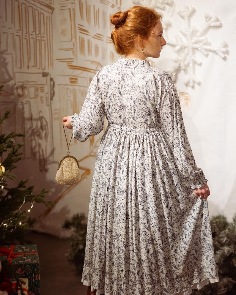 Vintage Midi dress with long voluminous sleeves and a placket. The dress features a drawstring at the waist and button closure. Lace embellishments adorn the sleeves and back of the dress. The color of the lace may vary while maintaining the color palette and artistic integrity. 
Fabric - viscose.