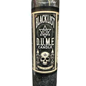 May include: Black glass candle with a label that says "Blacklist D.U.M.E Candle". The label has a skull with a third eye and a star with a circle in the centre.