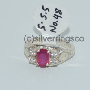 May include: A silver ring featuring a pink oval gemstone and smaller white gemstones. The ring is displayed on a white background with a tag labelled "S.S.S. No. 488".