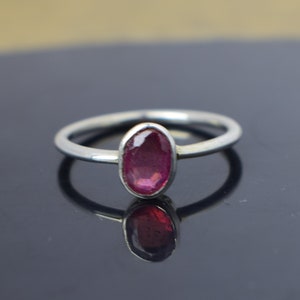 Puede incluir: Un anillo de plata con una piedra ovalada rosa.