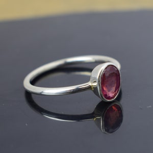Puede incluir: Un anillo de plata con una piedra ovalada rosa.