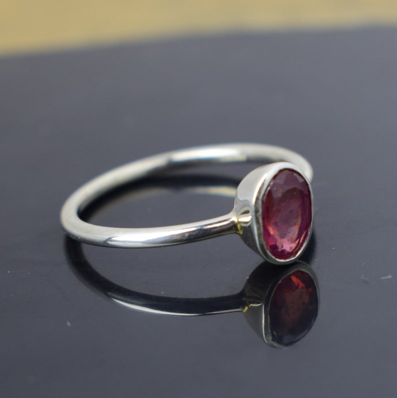 Puede incluir: Un anillo de plata con una piedra ovalada rosa.