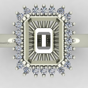 Puede incluir: Un engaste de anillo plateado con un centro rectangular y un halo de pequeñas piedras preciosas redondas. El engaste presenta un diseño de rayos de sol alrededor de la piedra central. El anillo se muestra sobre un fondo blanco.